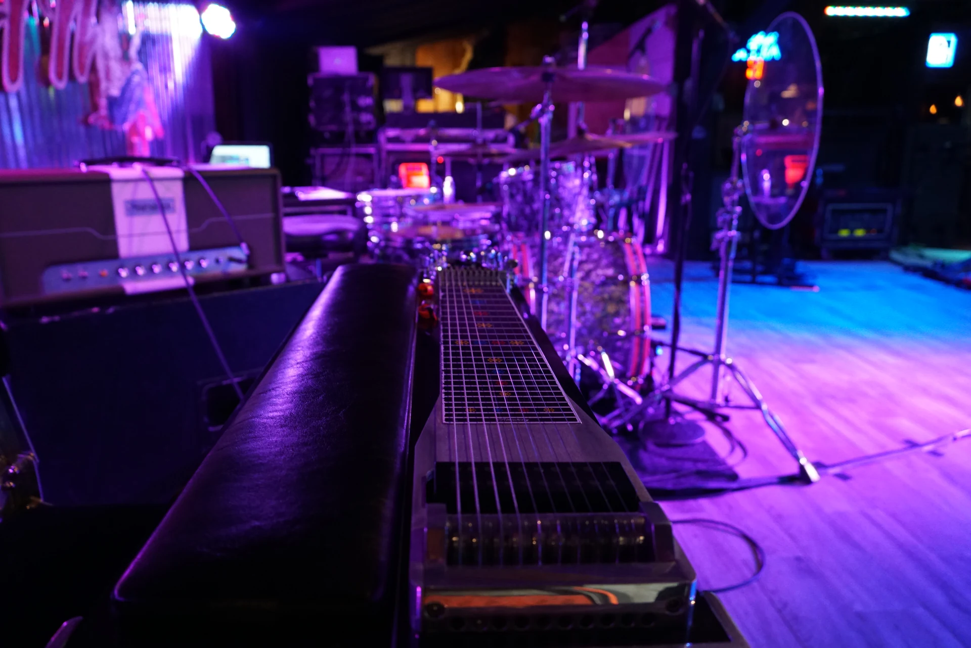 Stage instruments under purple and blue lights at The Barn